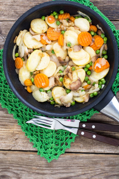 istock Potatoes fried with vegetables and mushrooms in frying pan 689774560