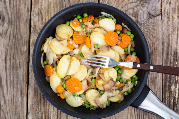 istock Potatoes fried with vegetables and mushrooms in frying pan 689774666