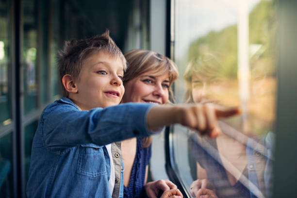 istock Happy little boy travelling on train with mother 689774720