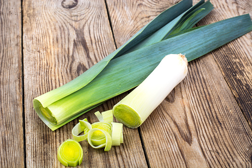 Leek, cut into pieces, on an old wooden table. Studio Photo
