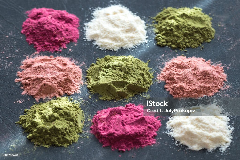 Various colorful superfood powders on dark background. Healthy food supplements, detox concept. Top view Ground - Culinary Stock Photo