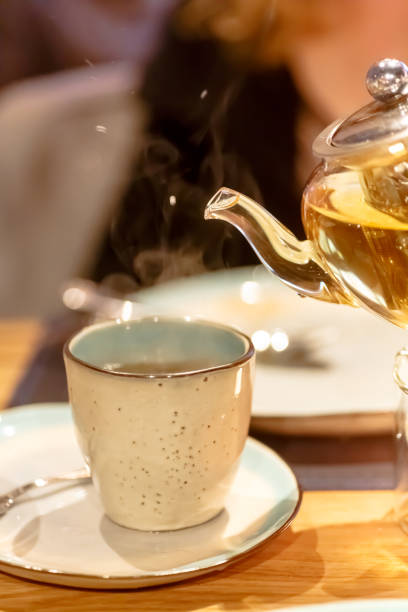 istock Hot tea is poured into the Cup from the glass teapot 689802104