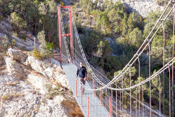 istock Hiker crossing a bridge in a sunny day in Spain 689807838