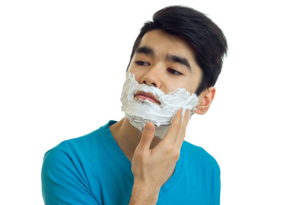 istock beautiful narcissistic guy looks away and putting a beard foaming close-up 689825402