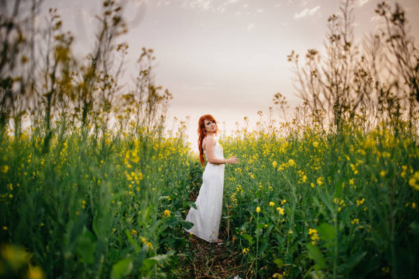 istock Young red-haired woman in a rapeseed field 689825848