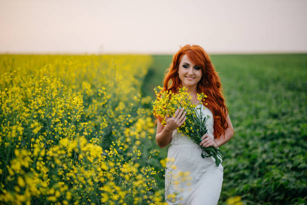 istock Young red-haired woman in a rapeseed field 689826030