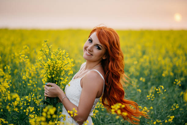 istock Young red-haired woman in a rapeseed field 689826120