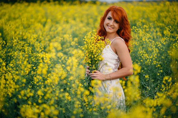 istock Young red-haired woman in a rapeseed field 689826146