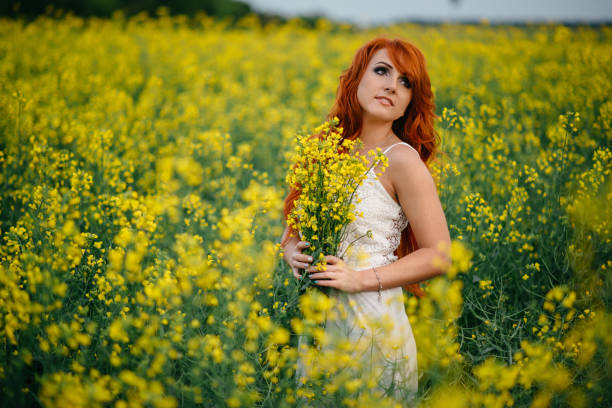 istock Young red-haired woman in a rapeseed field 689826186