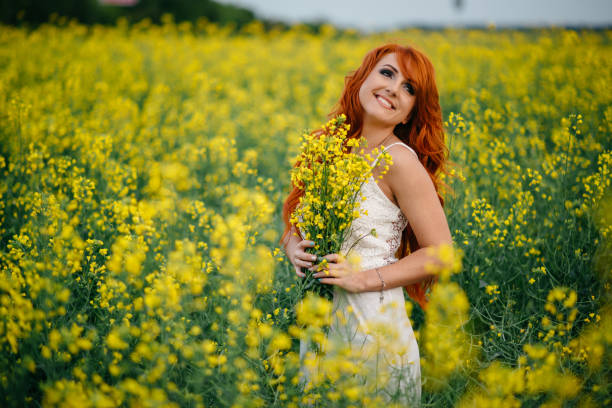 istock Young red-haired woman in a rapeseed field 689826244
