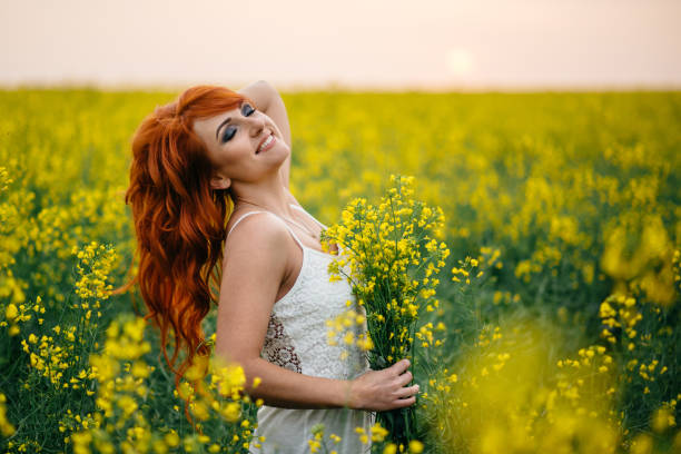 istock Young red-haired woman in a rapeseed field 689826318
