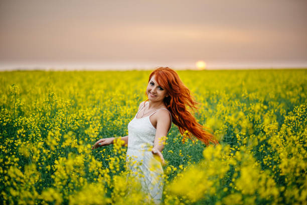 istock Young red-haired woman in a rapeseed field 689826474