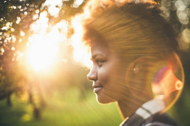 retrato de mudança de inclinação de menina negra na frente do pôr do sol - arch top - fotografias e filmes do acervo