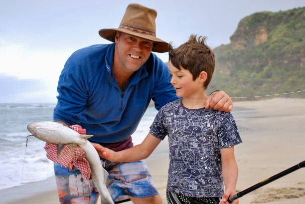 istock A Boys poses with his Father with his Fish 689847168