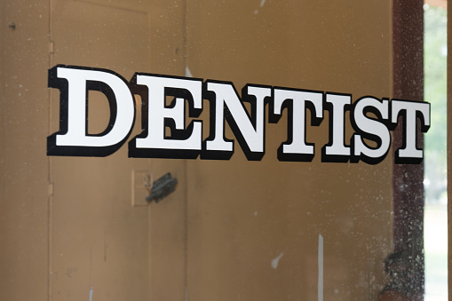 Vintage dentist office sign on glass door