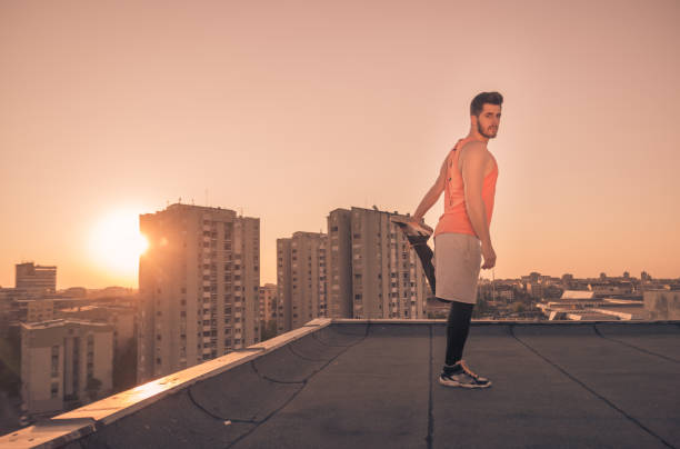 istock athlete man stretching rooftop roof, Sun sunset sunrise 689859906