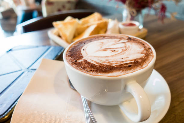 istock Hot chocolate in white cup on wooden table 689860416