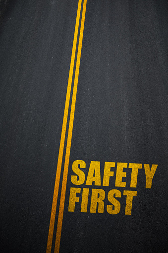 Safety First text on asphalt road.