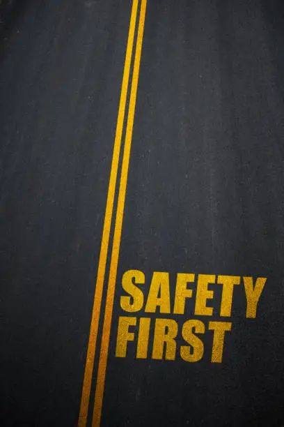 Photo of Safety First text on asphalt road