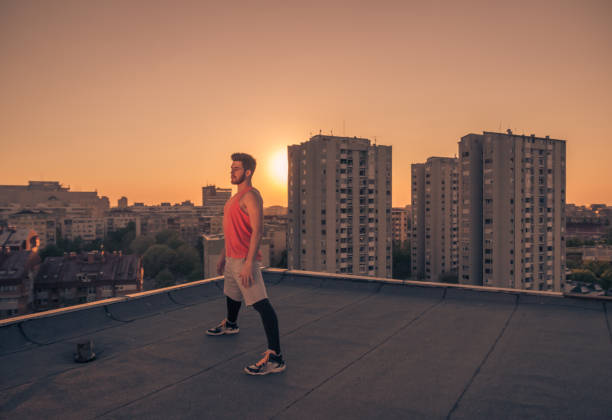 istock athlete posing roof rooftop, sunset sunrise Sun, orange color 689863620