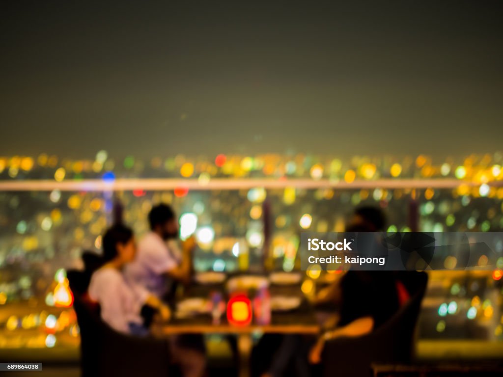 Blurred focus of rooftop restaurant with people dinning at night Rooftop Stock Photo