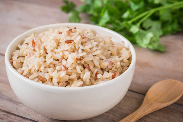 brown rice in bowl - brown rice cooked rice steamed stock-fotos und bilder