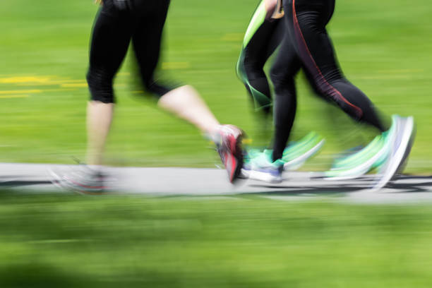 Front view of two people jogging in nature.