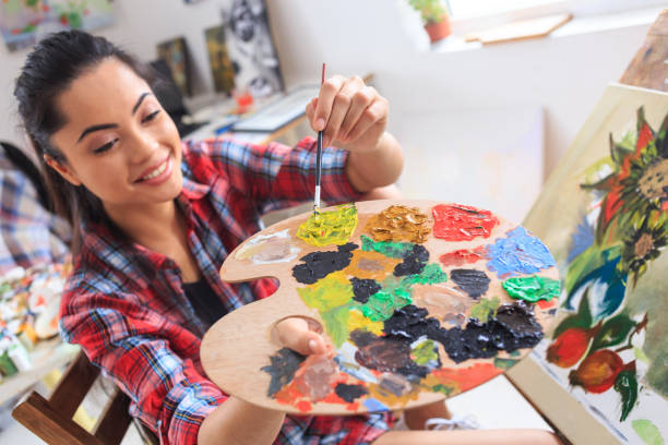 istock Young woman sitting and drawing at home 689890266