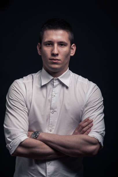 istock one young man portrait, upper body, arms crossed,black background 689890440