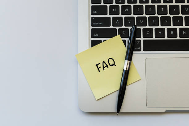 istock FAQ word concept on sticky note and a pen over top view flat lay isolated on white background. 689900352