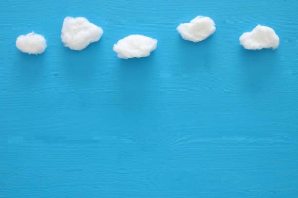 istock image of cotton shaped clouds over blue wooden background 689911886