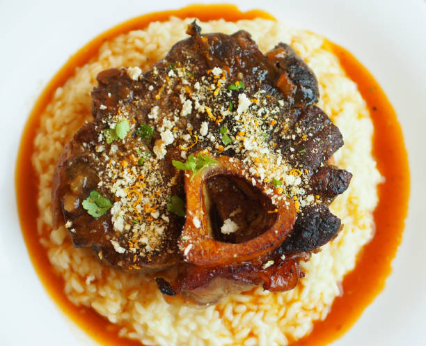 osso buco - миланская специальность из поперечных хвостовиков из мякоти, тушеных с овощами, белым вином и бульоном. - osso buco veal shank cooked стоковые фото и изображения