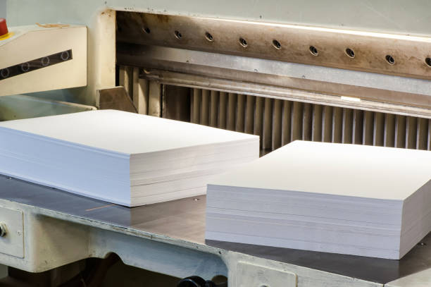 Reams of cut paper pages on a cutter machine