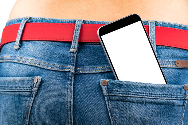 istock Smartphone with isolated white screen with empty space for text in a jeans pocket of a young slender girl 689928212