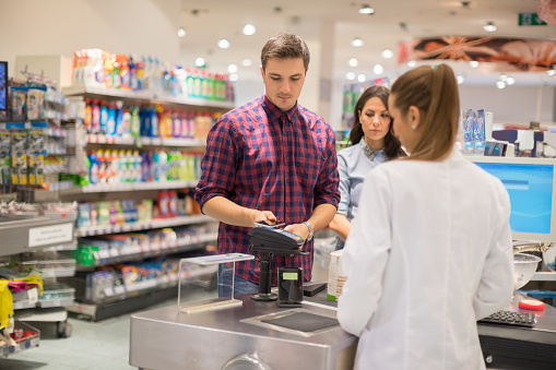 Man paying contactless in supermarket