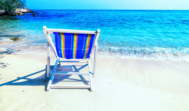 istock Bright chaise lounge on sand on seashore. 689931664