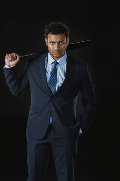 istock Confident young businessman with hand in pocket holding baseball bat and looking at camera 689936018