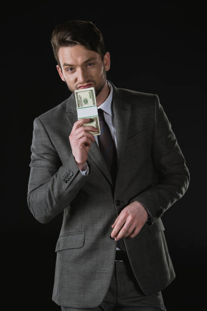 istock young businessman holding dollar banknotes isolated on black 689936508