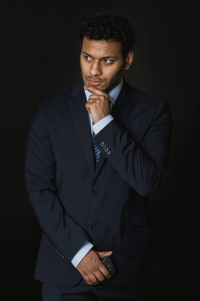 istock young pensive african american businessman standing isolated on black 689936558