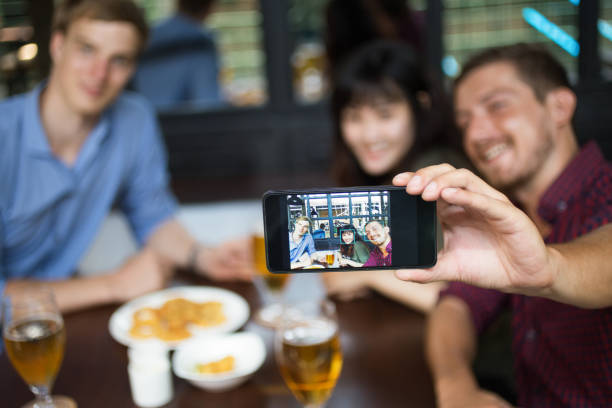 istock Three Friends Taking Selfie Photo in Pub 689940922