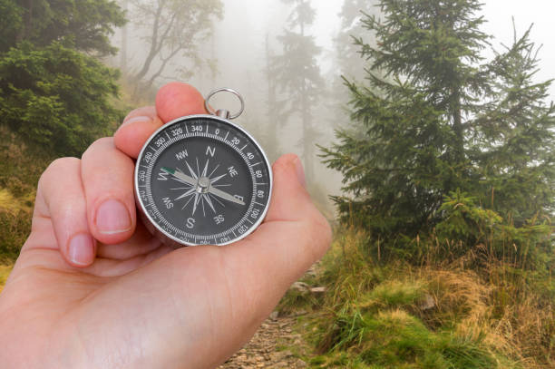 istock Woman with compass is seeking a right way in forest 689943906