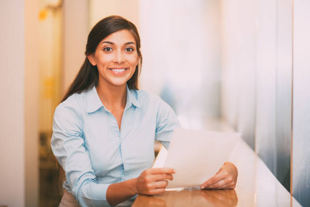 istock Smiling Pretty Woman Holding Document in Cafe 689944782