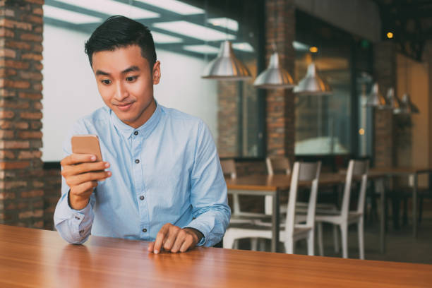 istock Surprised Asian Man Reading Message on Smartphone 689947628