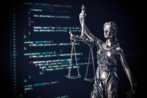 Justice statue with code on monitor device in background. programming code law crime justice internet statue themis concept