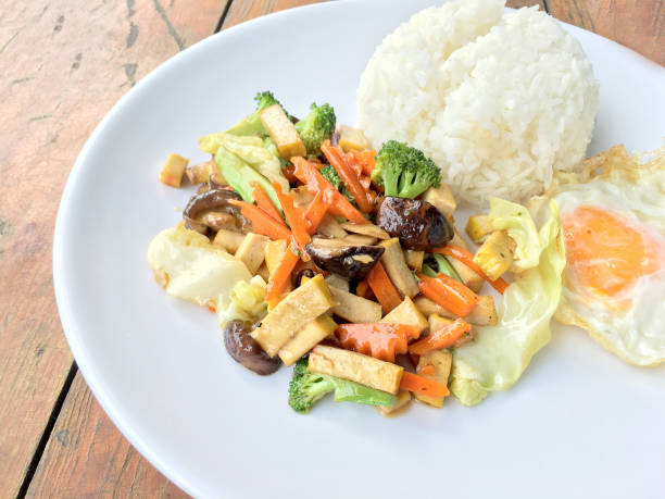 tofu sautés avec légumes et oeuf au plat - tofu chinese cuisine vegetarian food broccoli photos et images de collection