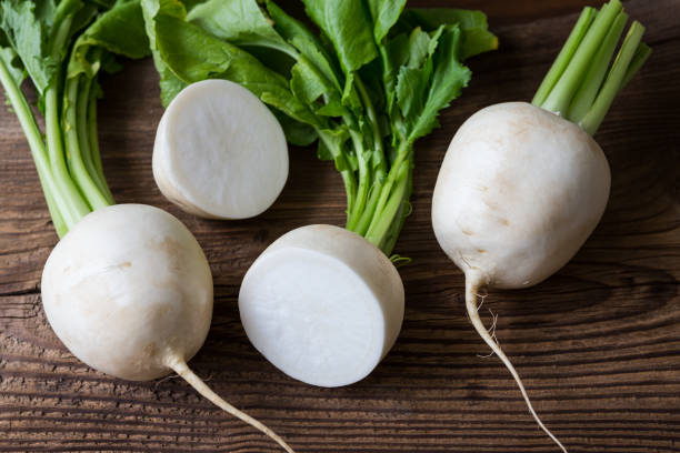 Tasty fresh crude white round japanese radish with green stems and leaves Tasty fresh crude white round japanese radish with green stems and leaves brassica rapa stock pictures, royalty-free photos & images