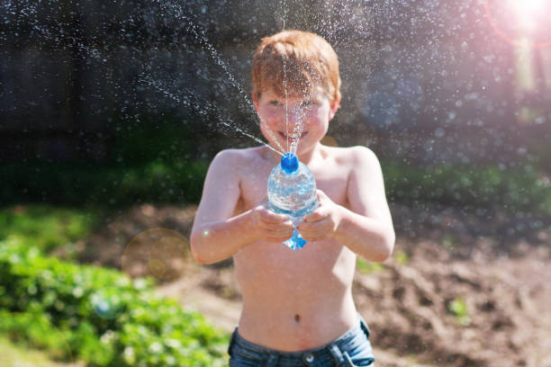 istock Red-haired country boy splashes water 689955734