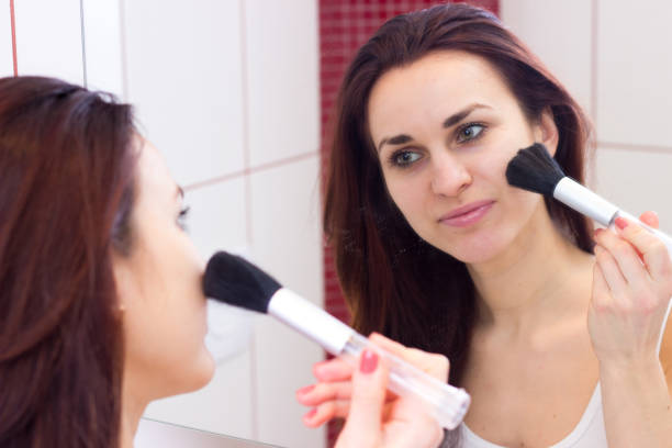 istock Young woman powdering in bathroom 689956222