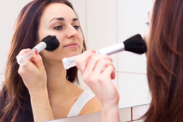 istock Young woman powdering in bathroom 689958856