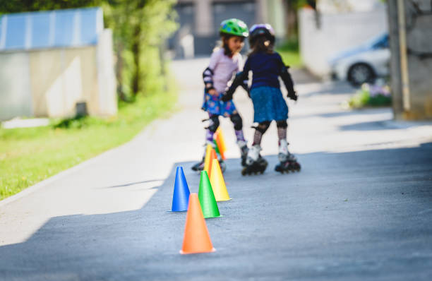 istock Children learning to roller skate on the road with cones. 689959104